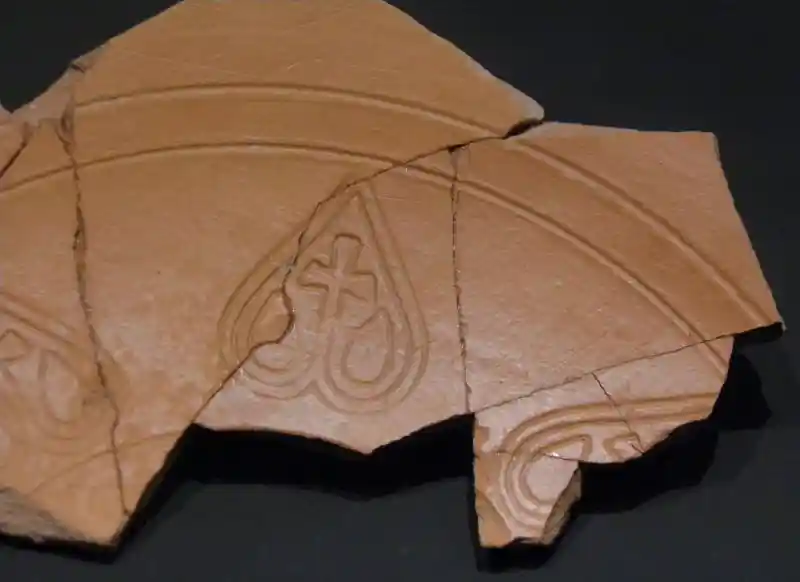 Cross inside hearts as sun rays on a terra bowl